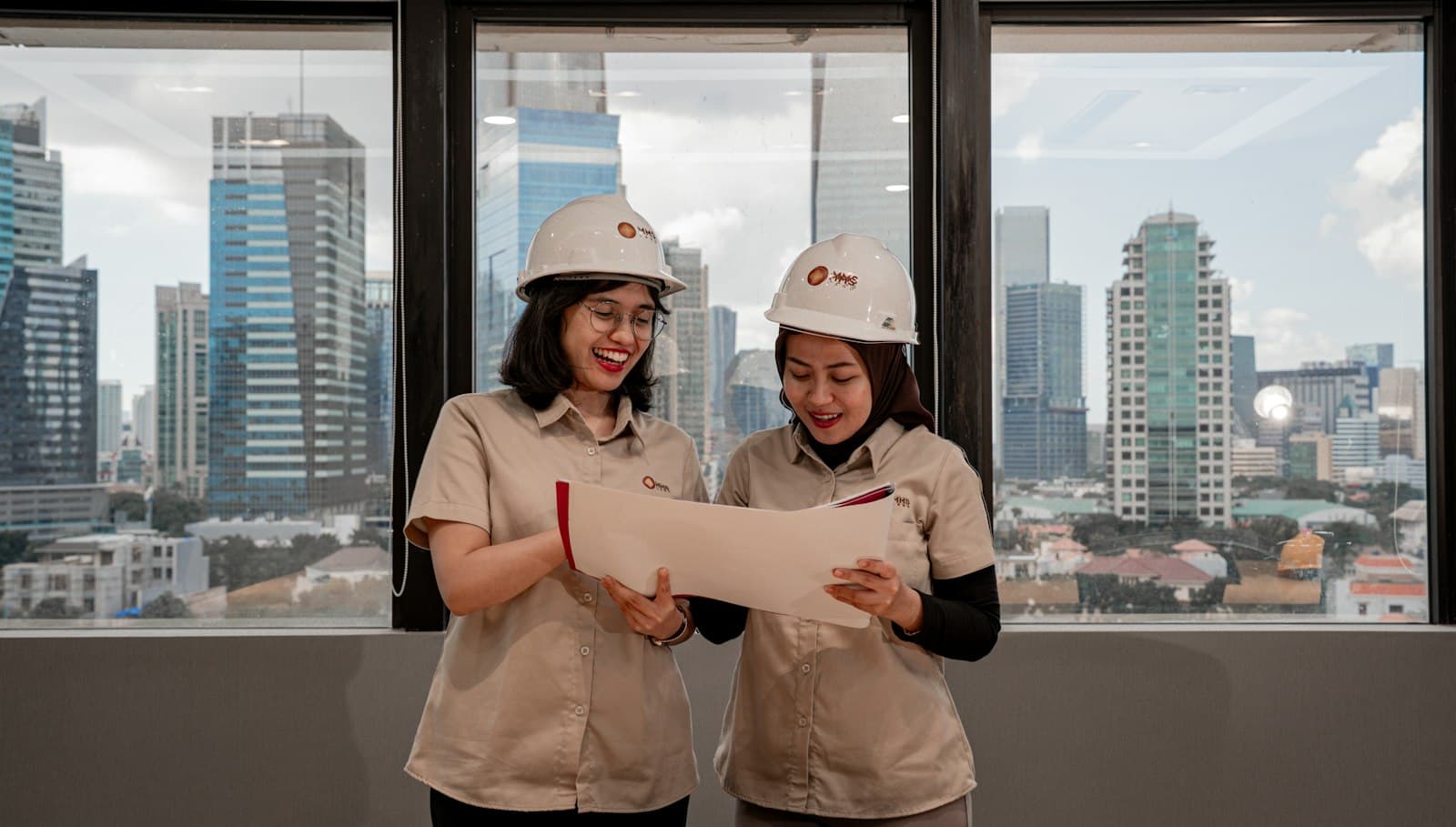 Engineers in hard hats reviewing project drawings together