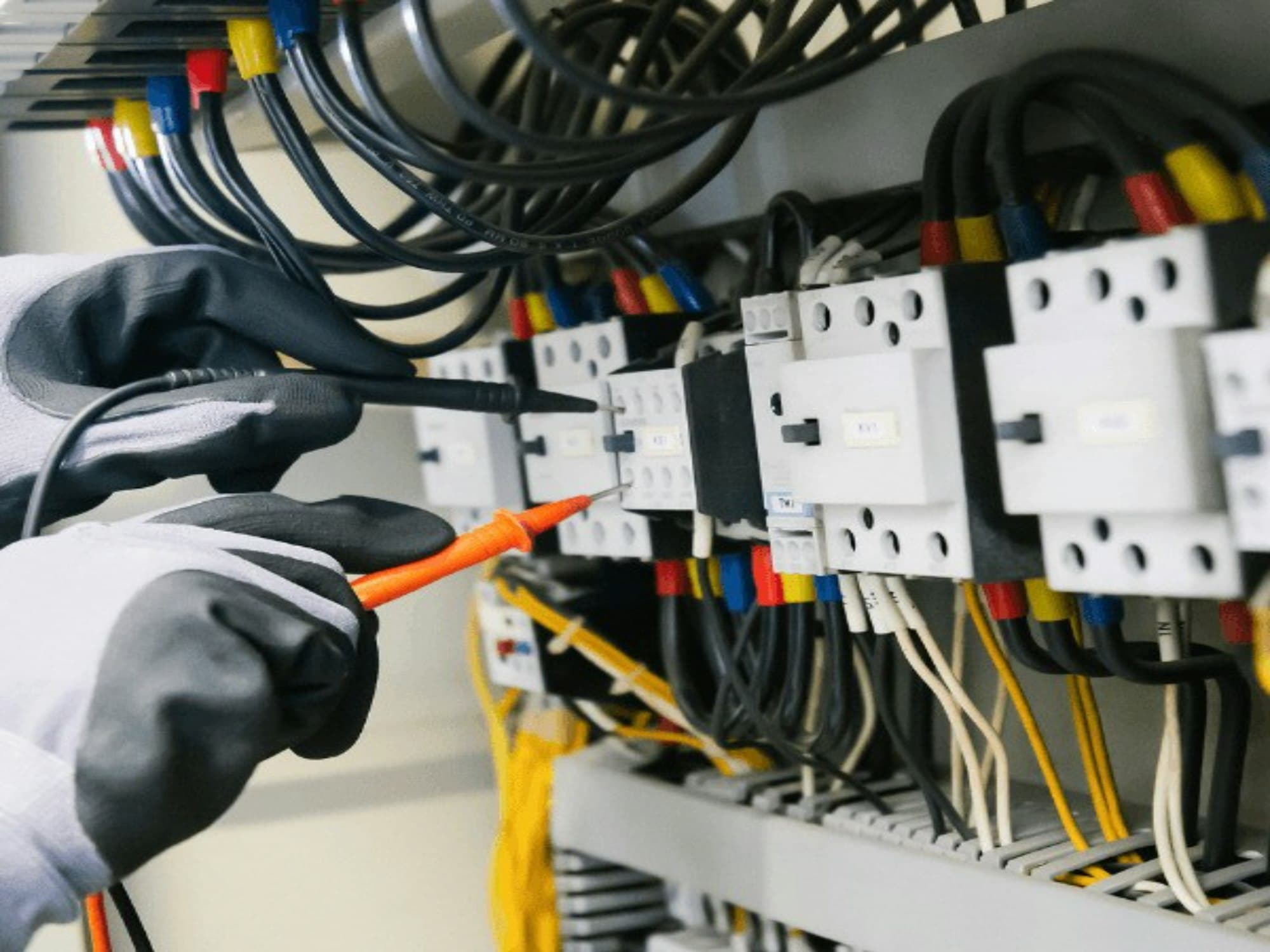 Engineer tracing control wiring with a test probe