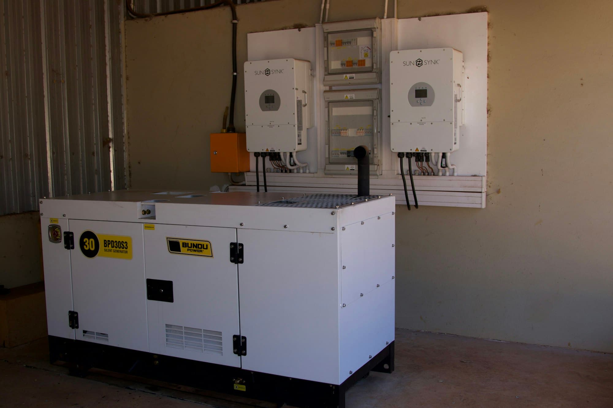 Newly installed silent-canopy generator with wall-mounted power equipment