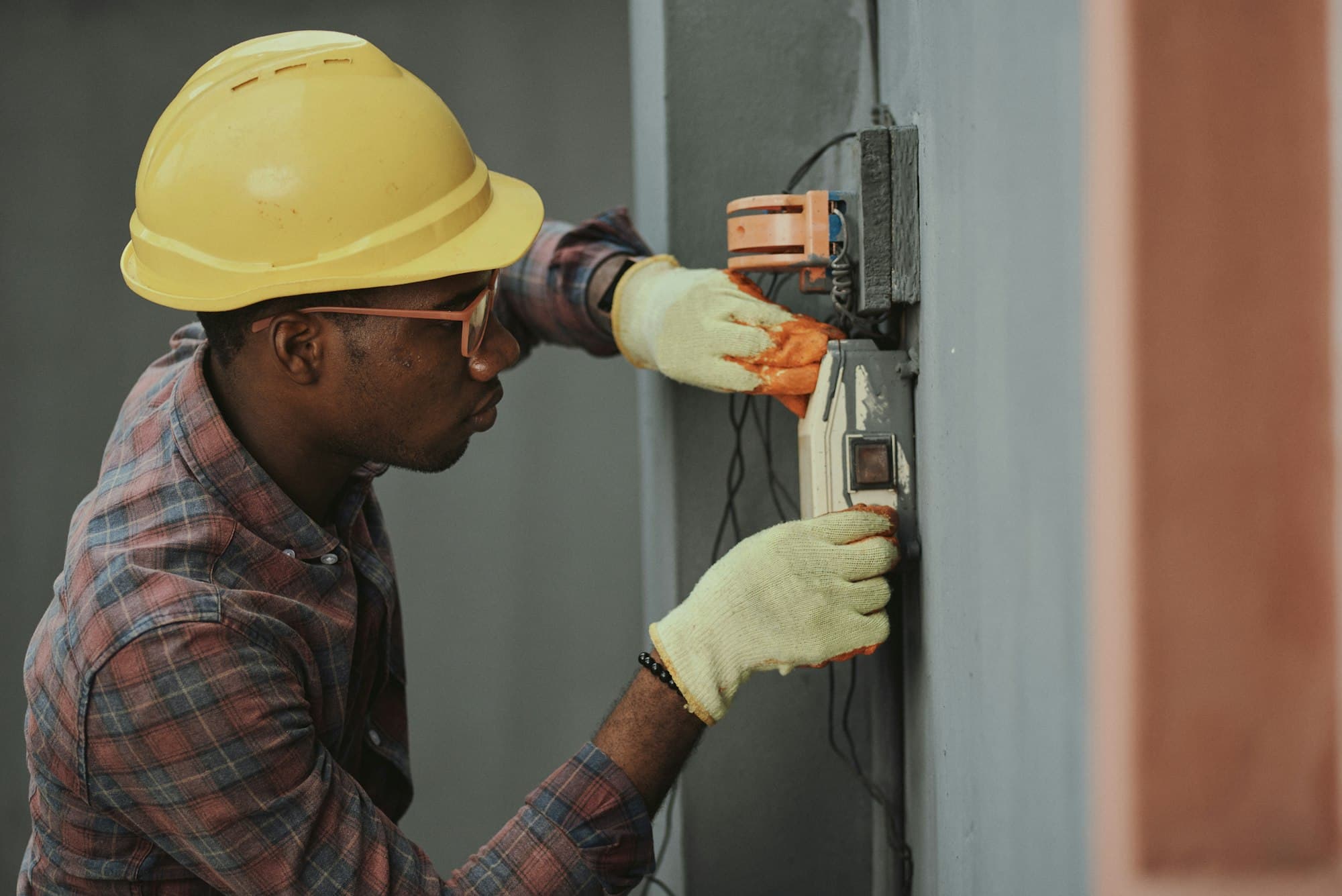 Field technician in a hard hat testing electrical equipment